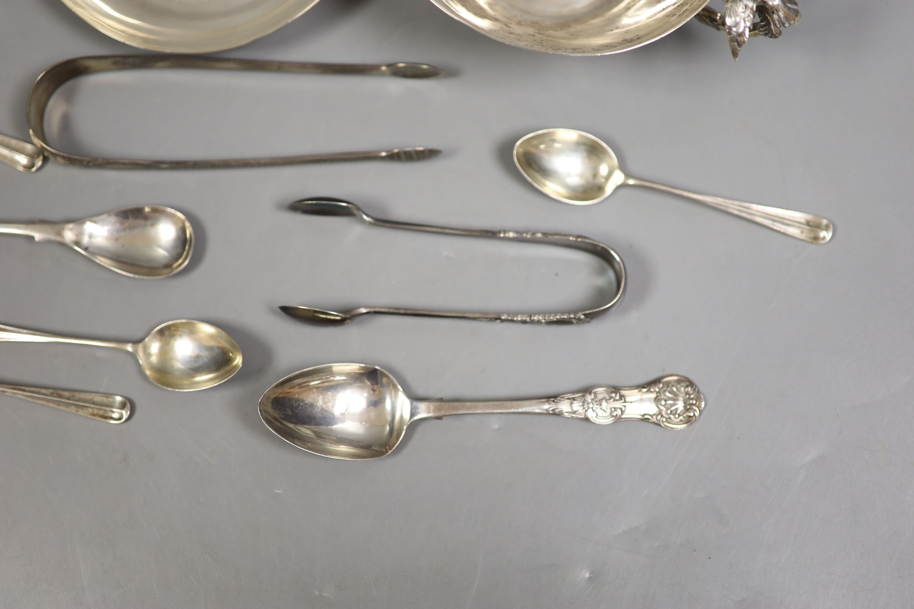 A Persian white metal tea cup and saucer and small sile items including two pepperettes, a trinket box and assorted minor flatware